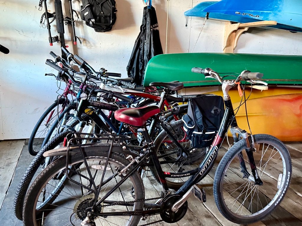 The Fisherman's Quay guest bicycle fleet with panniers, parked beside the kayaks