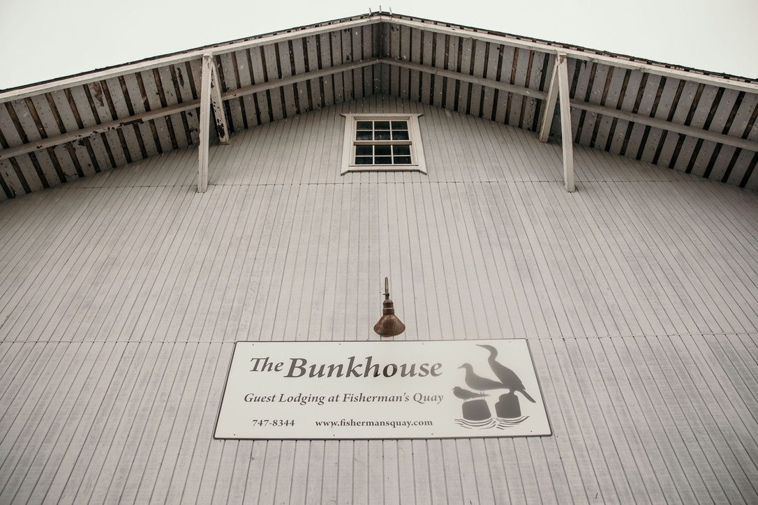 The painted Bunkhouse sign on the grey gable end of the Fisherman's Quay building