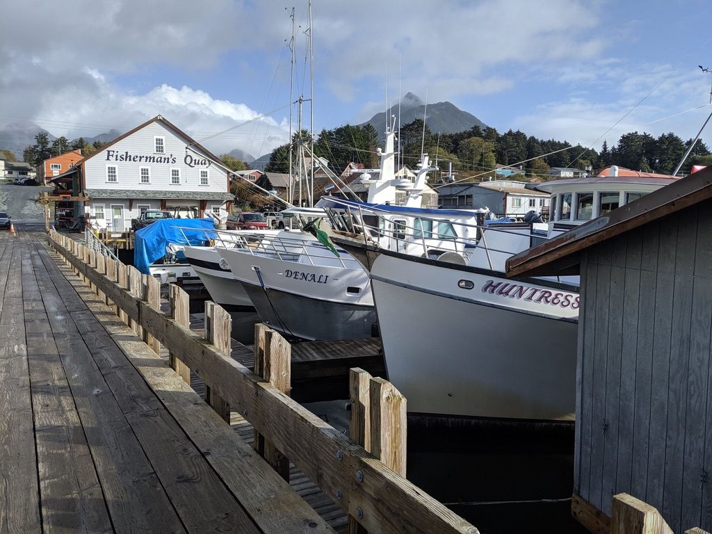 Fishing boats moored along the Fisherman's Quay dock with the painted building sign behind