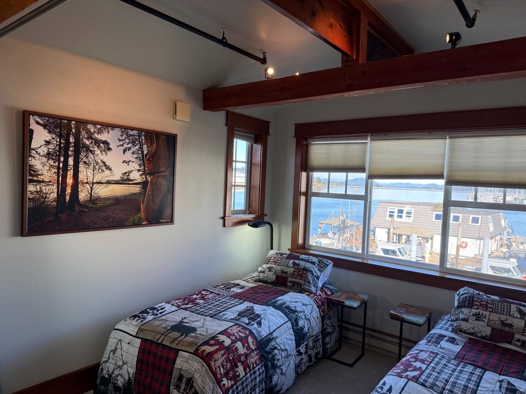 Twin bedroom in The Loft with windows looking out over the boat harbor and dock