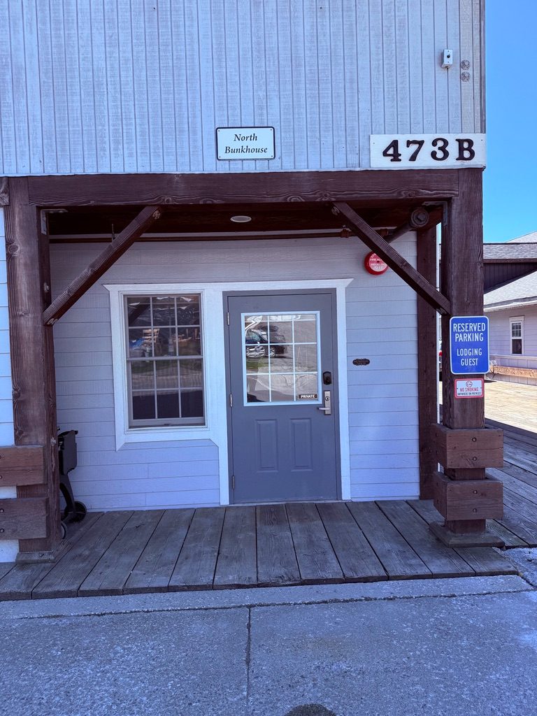 Private entrance to the North Bunkhouse at 473B with a covered timber porch and reserved guest parking sign