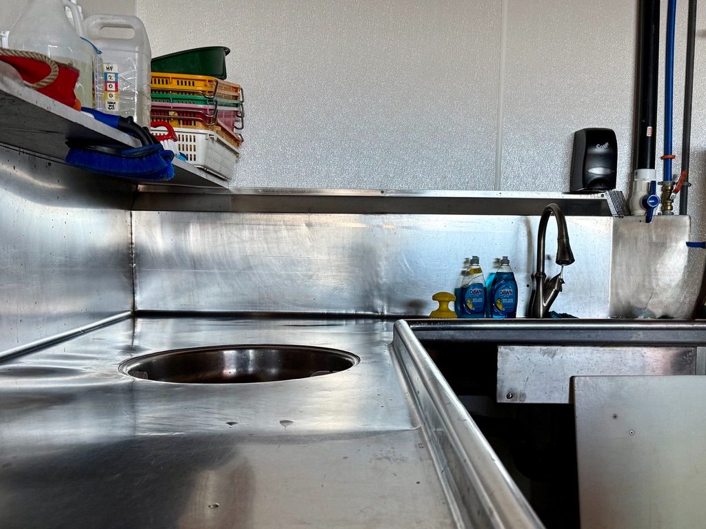 Stainless fillet station and wash sink in the Fisherman's Quay seafood processing room