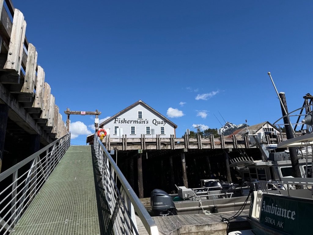 Looking up at the Fisherman's Quay building from the ramp down to the floats, with boats moored alongside