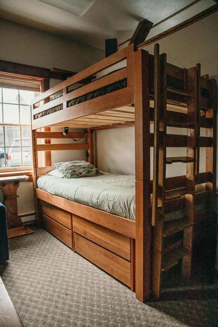 Heavy timber bunk bed in the South Bunkhouse with built-in stairs and storage drawers below